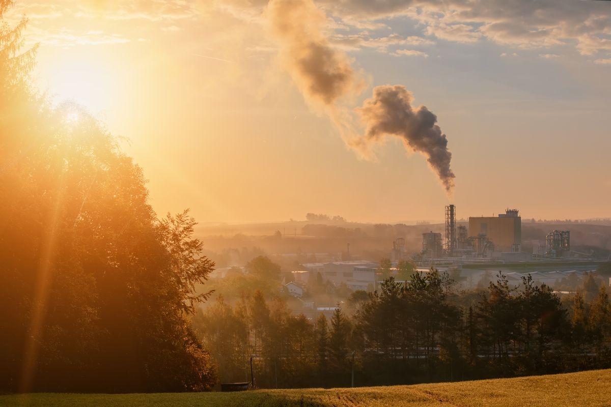 Sunrise of industrial cityscape with with smoking factory, ecology and pollution concept